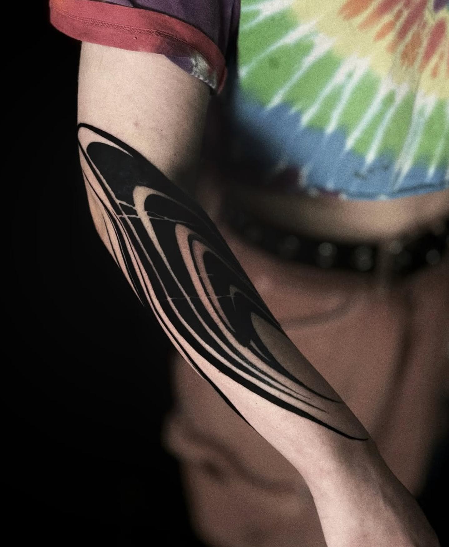 Blackwork abstract tattoo with flowing lines on forearm