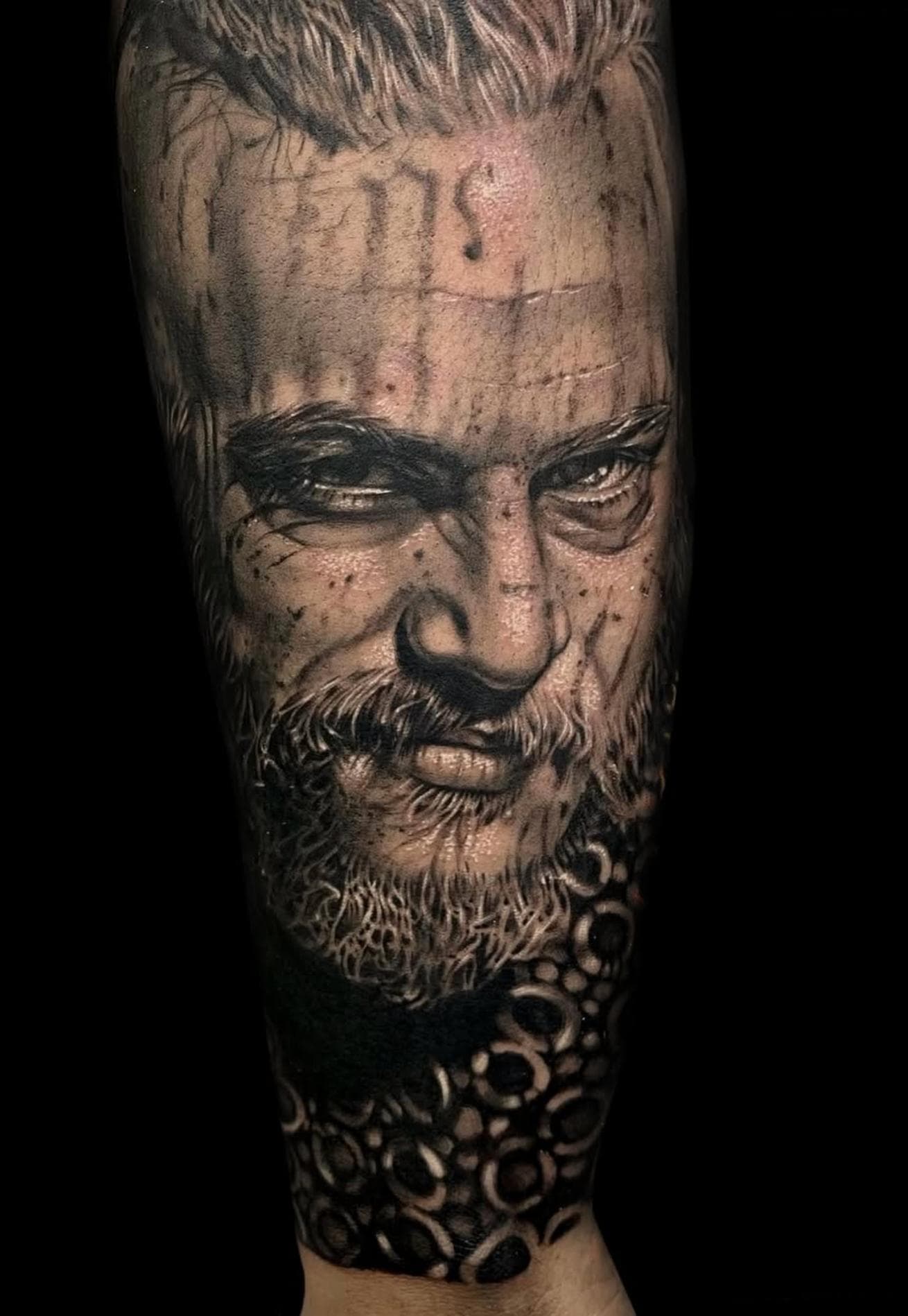 Black and grey realistic portrait tattoo on forearm