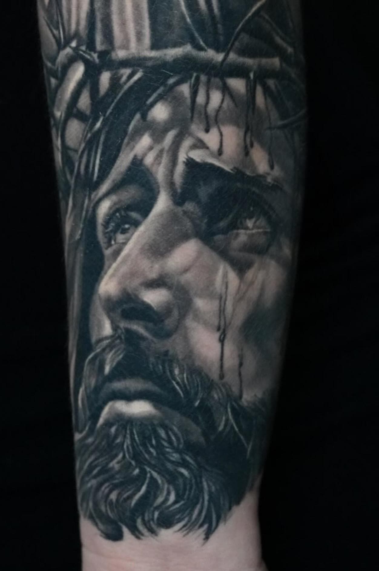 Black and grey realistic portrait tattoo on forearm