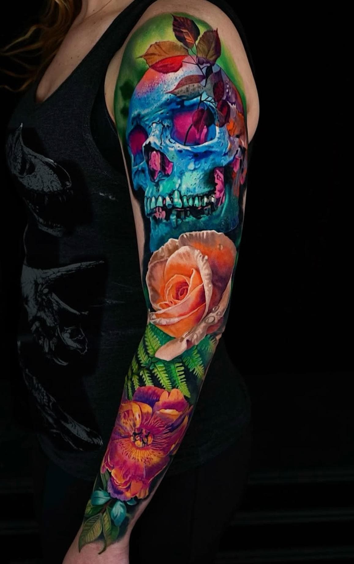 Colorful skull and floral full sleeve tattoo on arm